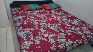 Una cama con colcha estampada y dos almohadas.