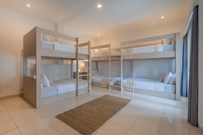 A room with bunk beds, a rug, and a lamp. - Luxury 10-bedroom private villa estate located in Seminyak, offering daily breakfast, a full-time private chef, airport transfers, complimentary massages, housekeeping, and a dedicated driver. (Badung)