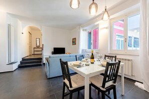 A dining area with a table, chairs, and a television in the background. - Charming Apartment Sestri Levante (Sestri Levante)