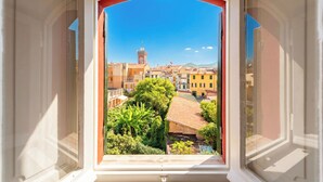 A window with an open view of a town, including buildings and a tower. - Charming Apartment Sestri Levante (Sestri Levante)
