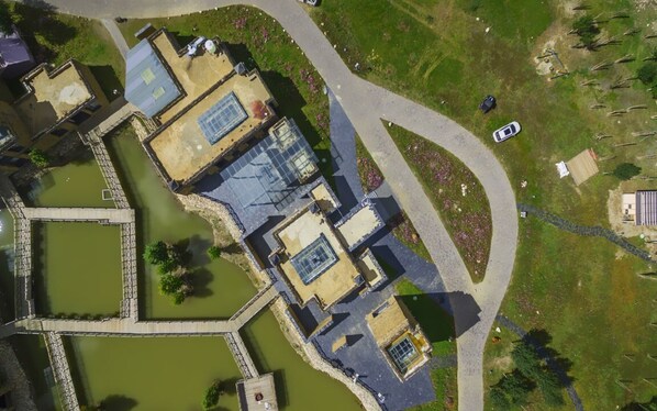 Vista aérea de un complejo con edificios interconectados, senderos y cuerpos de agua.