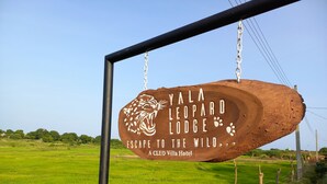 A wooden sign with a leopard design and text for Yala Leopard Lodge, indicating a nature-themed accommodation. - yala leopard lodge (Kirinda)