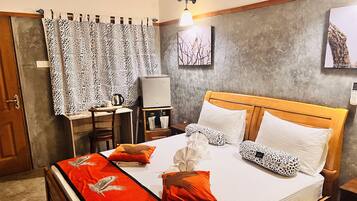 A neatly arranged bedroom with a bed, pillows, a desk, and a chair.