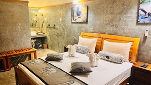 A hotel room with a bed, bedside tables, a bench, a bathroom with a sink, and a mirror. - yala leopard lodge (Kirinda)