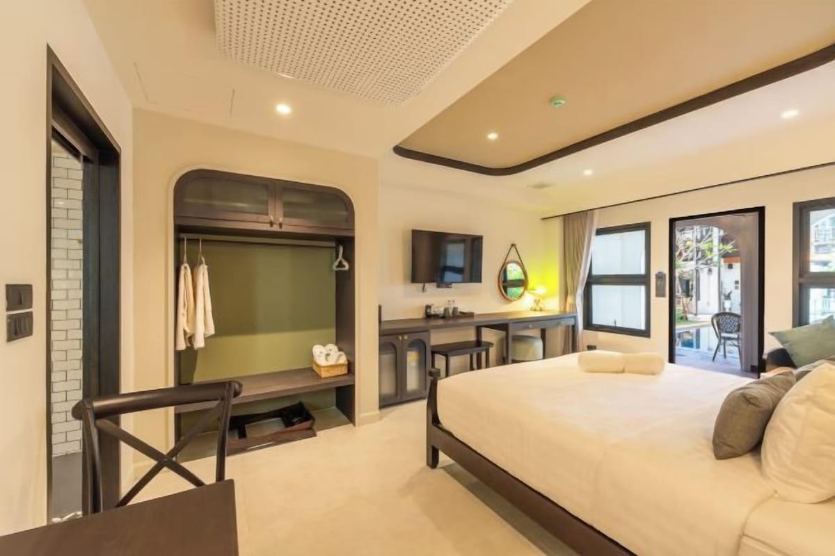 A modern hotel room with a bed, desk, and seating area.