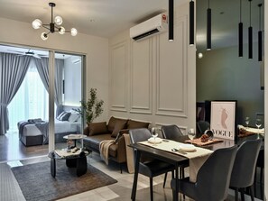 A modern living room with a sofa, coffee table, and dining area with a table set for two.
