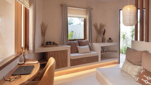 A modern room with a wooden desk, a cushioned seating area, and a hanging light fixture. - Dune Seseh (Cemagi)