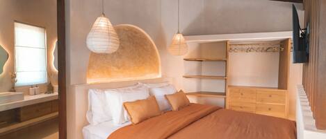 A bedroom with a large bed, a wooden wardrobe, and a built-in shelf unit.