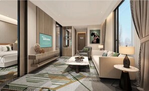 A modern hotel room with a bed, a sofa, a coffee table, and a TV screen displaying a welcome message. - Argyle Grand Hotel (Syokimau)