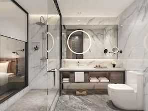 Un baño moderno con cabina de ducha de vidrio, suelo de baldosas de mármol, un espejo grande con iluminación circular y un inodoro blanco.
