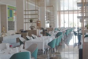 A spacious dining area with multiple tables and chairs, a modern interior design, and large windows providing natural light. - Argyle Grand Hotel (Syokimau)