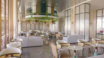 A modern interior with seating areas, tables, and a unique ceiling design.