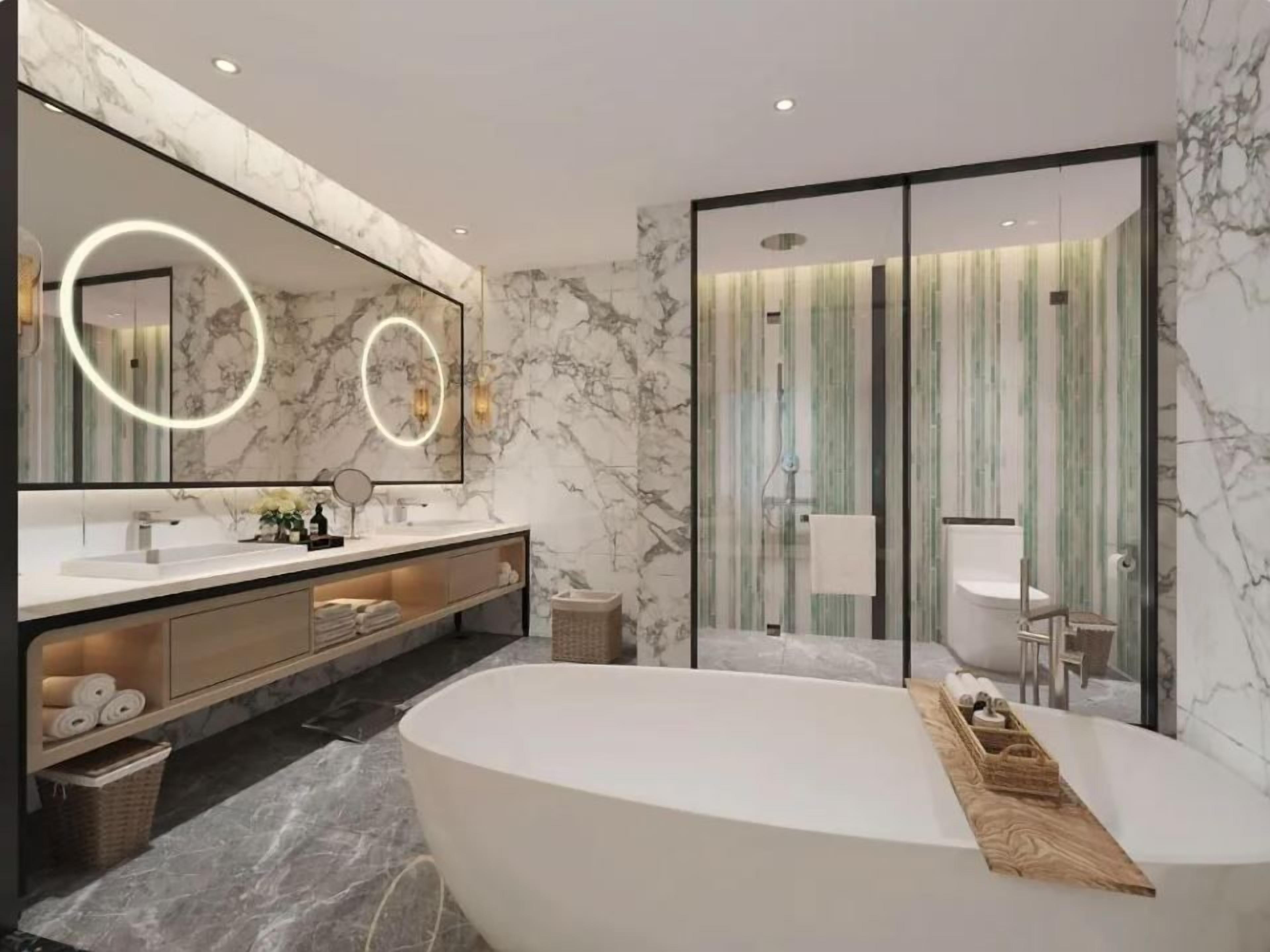 A modern bathroom with a large bathtub, a vanity with a mirror, and a shower area.