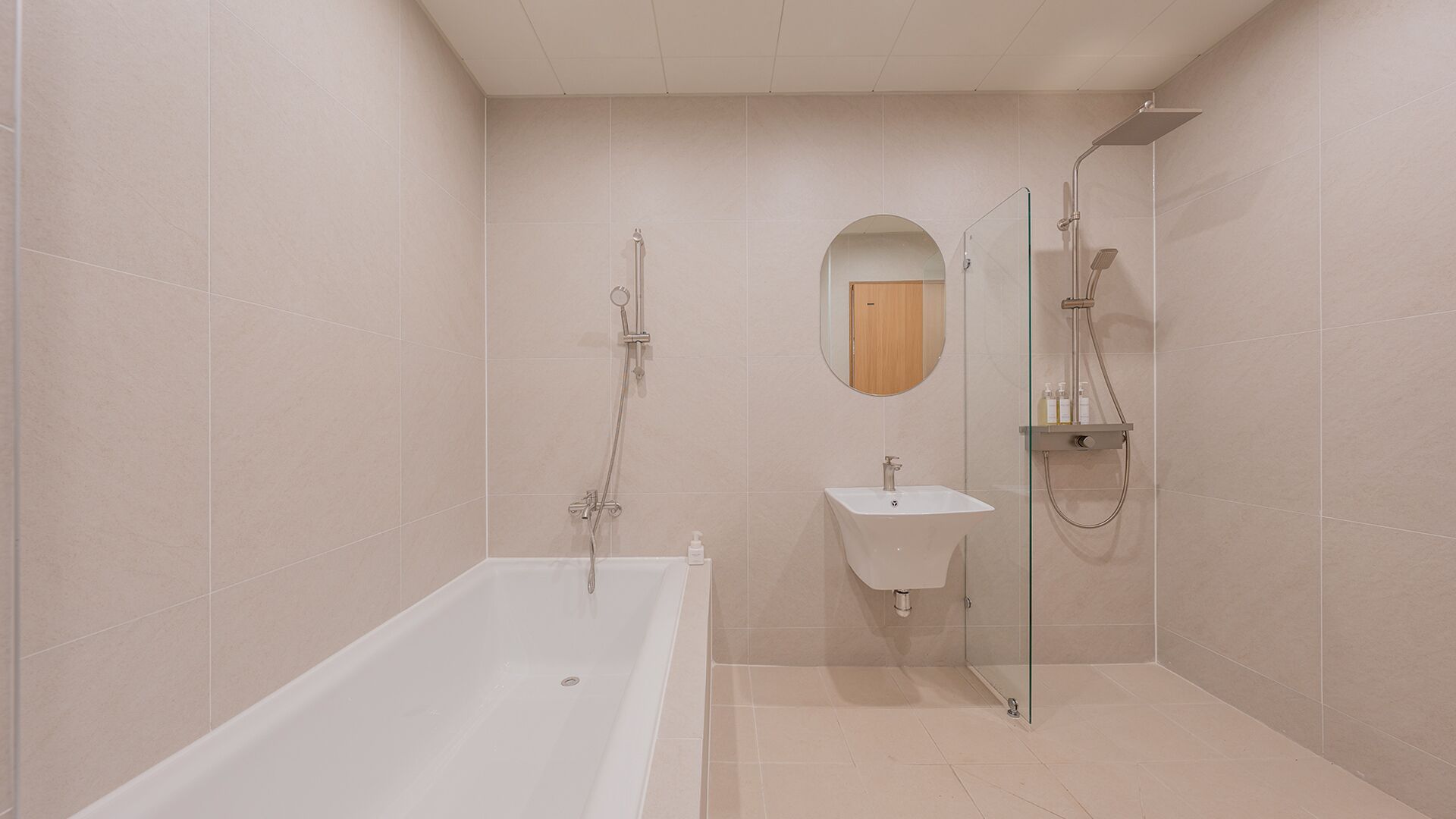 A modern bathroom with a bathtub, a sink, and a shower area.