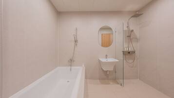 A modern bathroom with a bathtub, a sink, and a shower area.