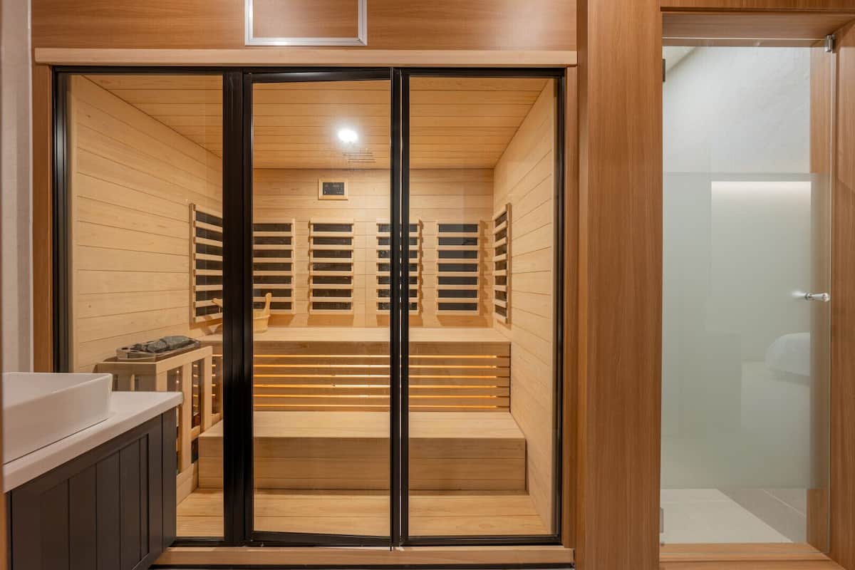 A sauna room with wooden benches and a glass door.