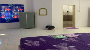 Un dormitorio con cama, armario, espejo y zona de ducha.