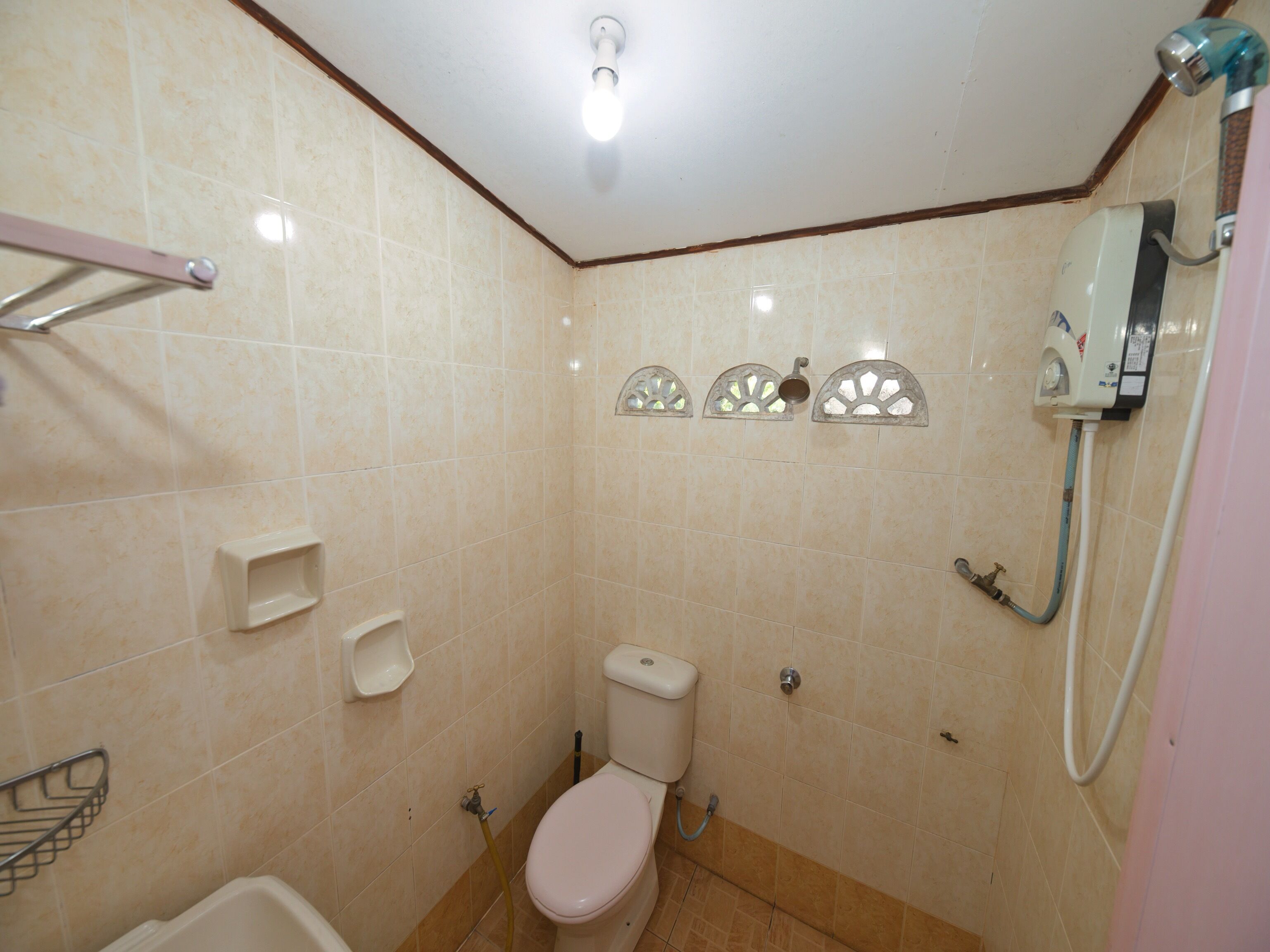 Un baño pequeño con inodoro, ducha y secador de manos.