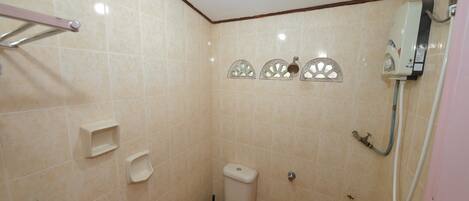 Un baño pequeño con inodoro, ducha y secador de manos.
