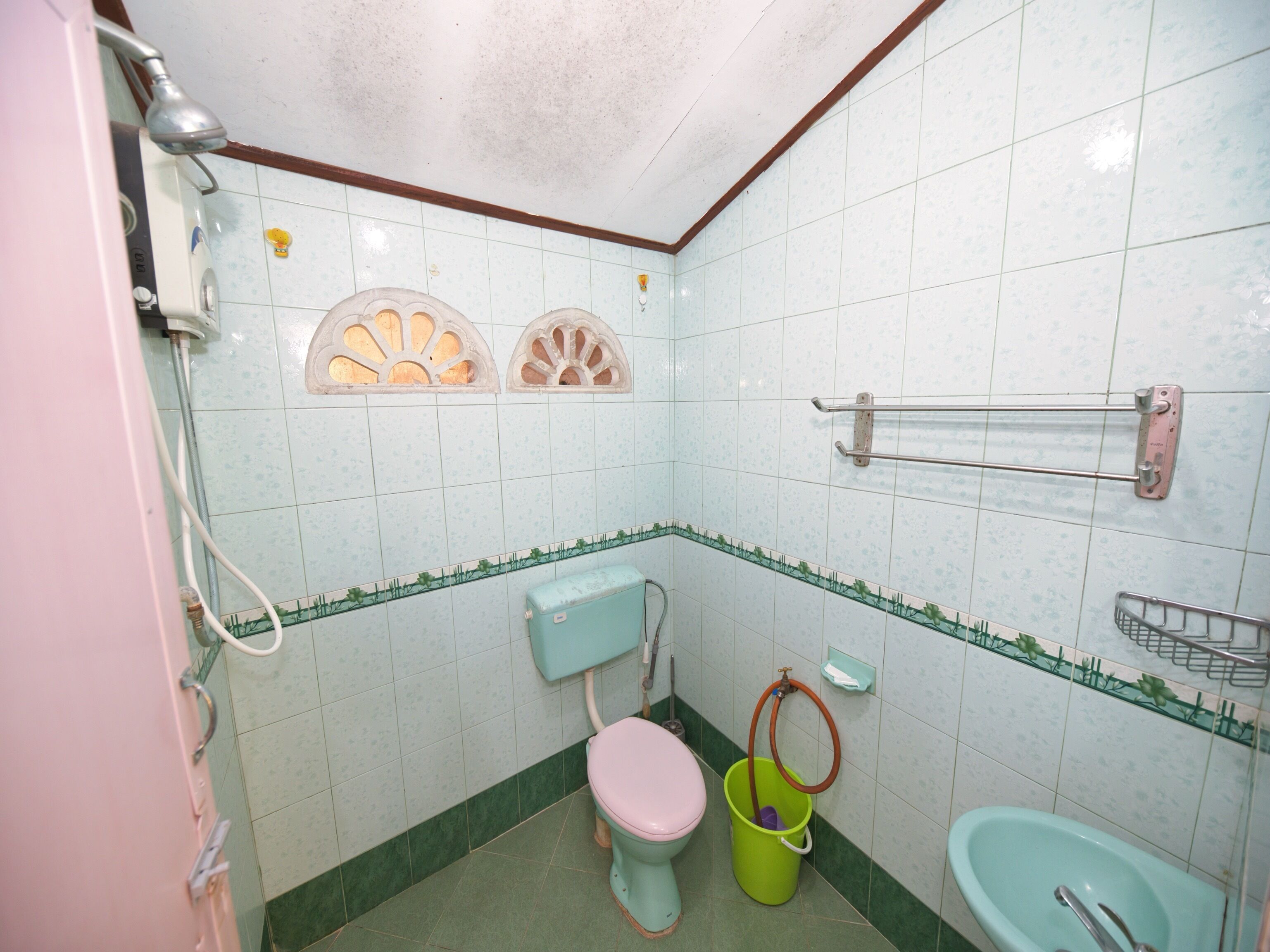 Une petite salle de bain avec des toilettes, un lavabo et une douche.