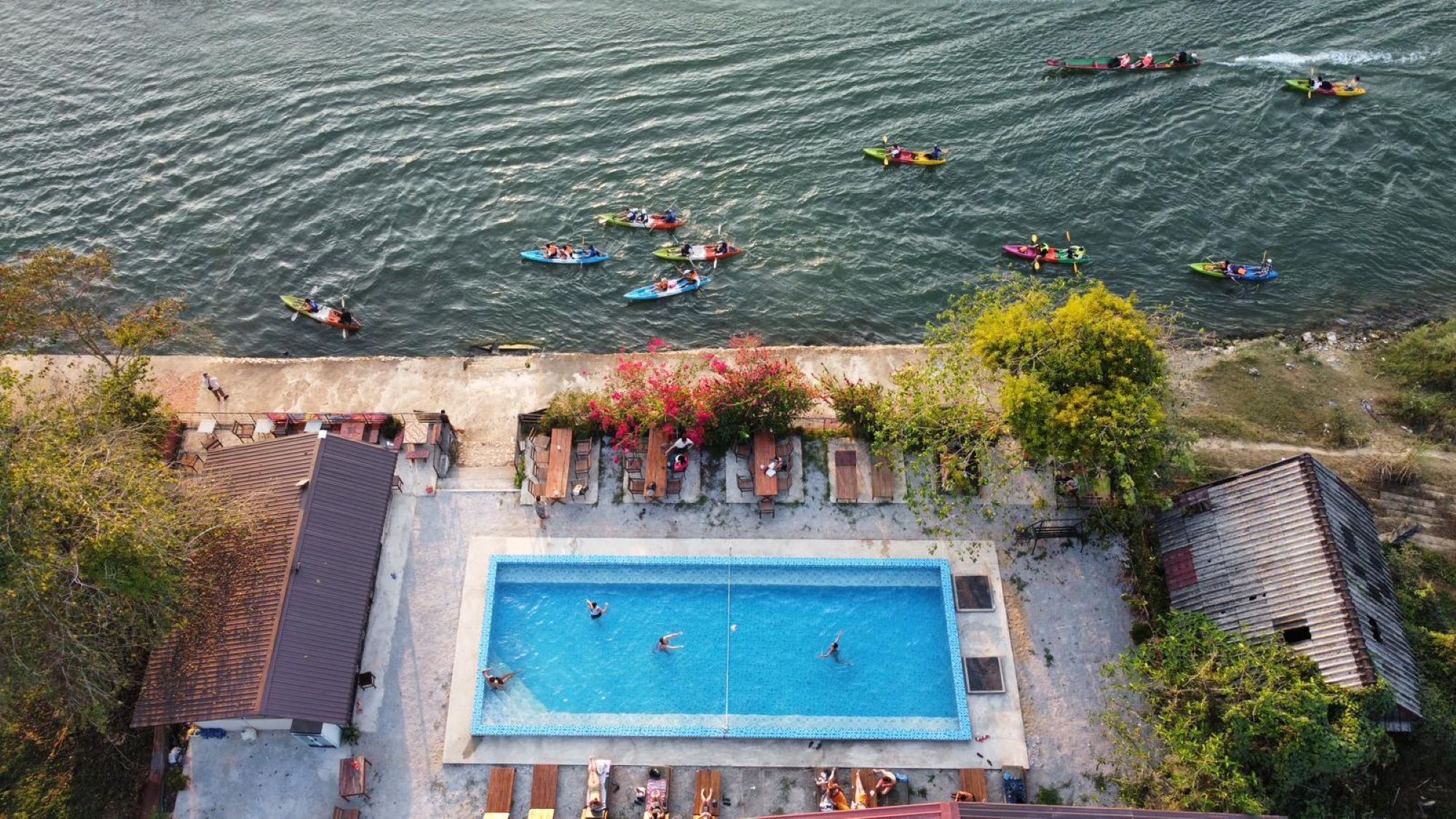 An aerial view of a swimming pool surrounded by a patio area with outdoor seating.