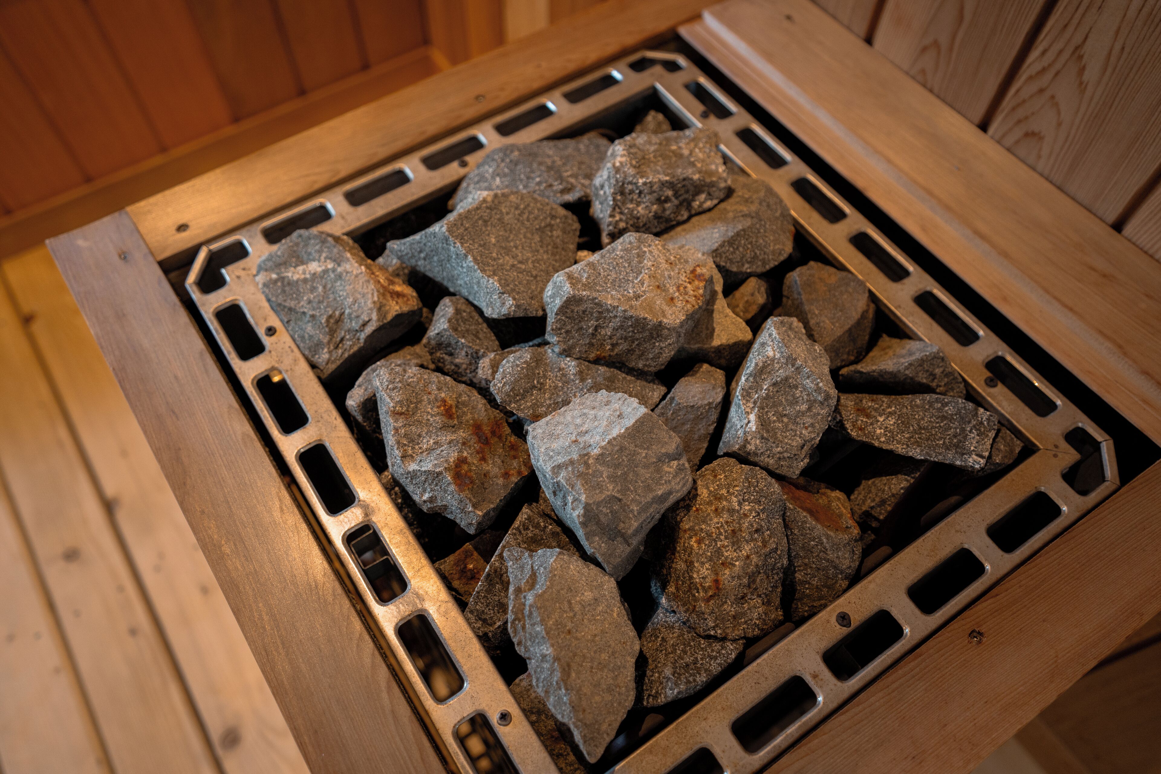 A wooden structure with a metal grate filled with rocks.