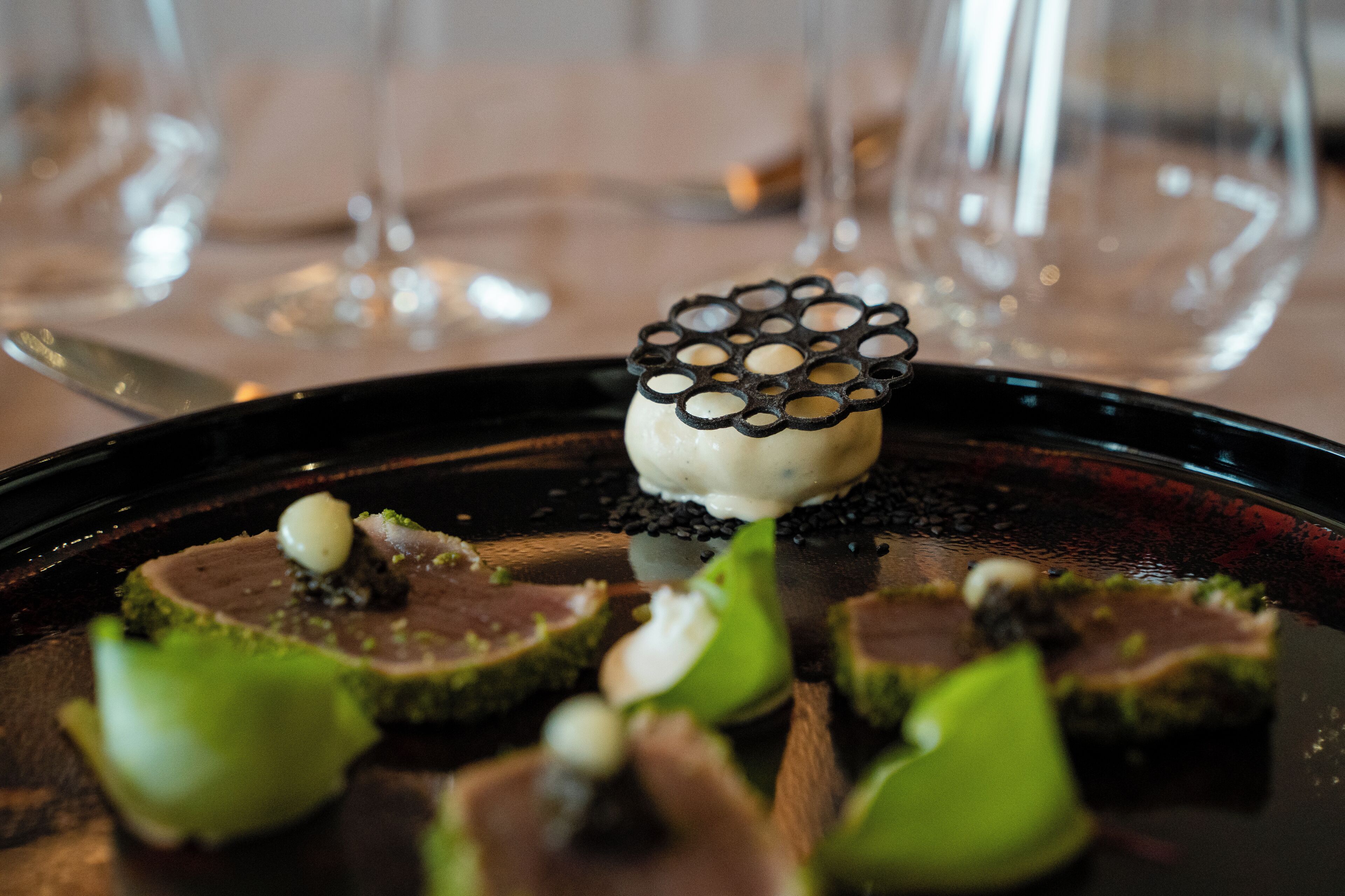 A dessert plate with a central piece of cake and surrounding garnishes.