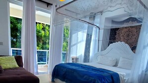A bedroom with a bed under a canopy, a ceiling fan, and a view of greenery outside. - Gustavo Homes Mombasa (Mombasa)