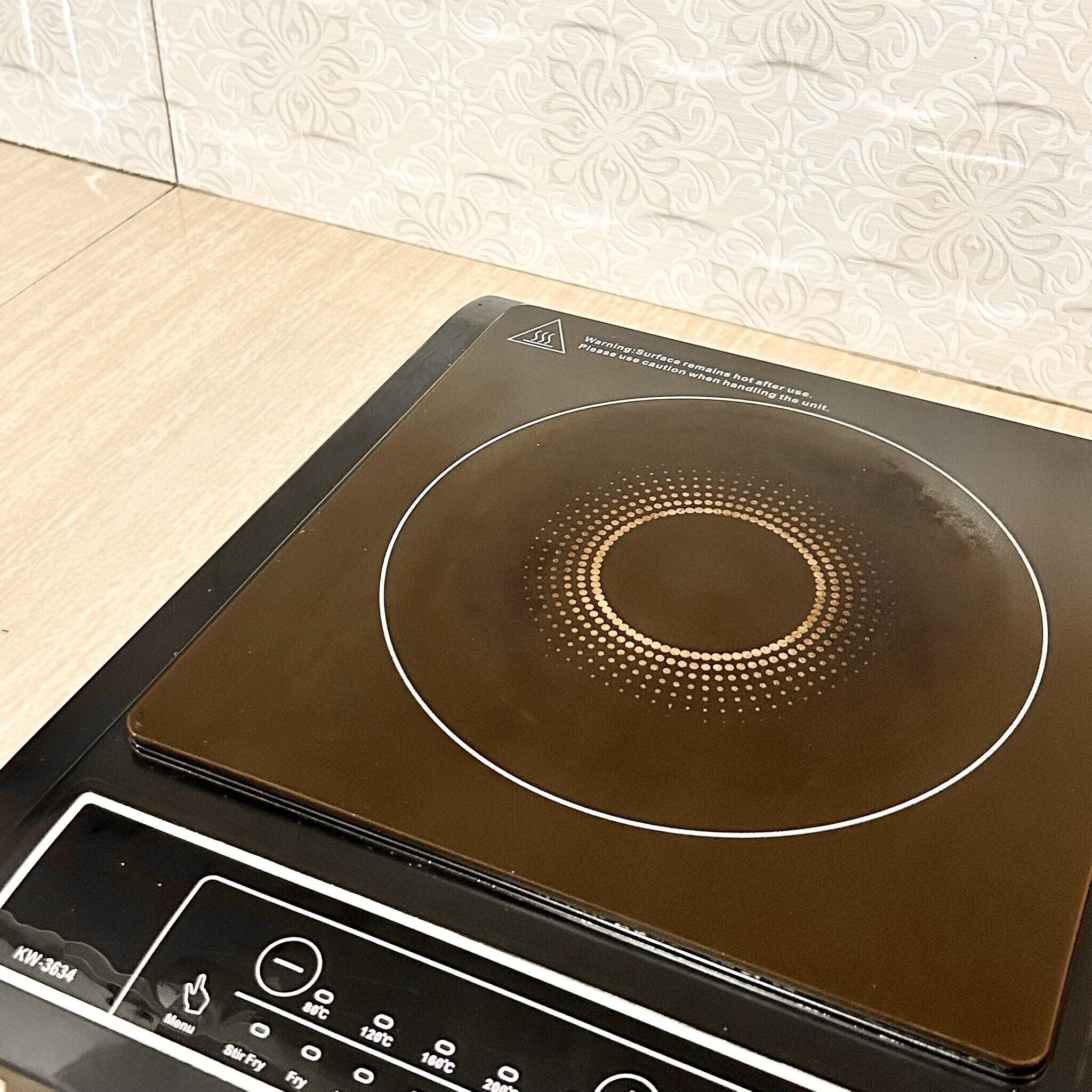 Een keuken met een inductiekookplaat en bedieningspaneel.