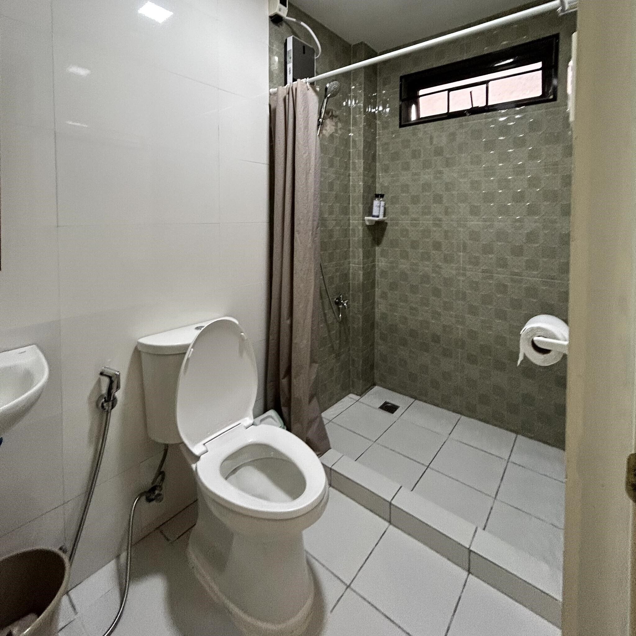 Un baño con inodoro, ducha y lavamanos.