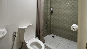 Un baño con inodoro, ducha y lavamanos.