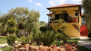Un bâtiment à deux étages, doté d’une façade jaune et d’un toit recouvert de tuiles rouges.