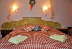 Una habitación de hotel con una colcha a cuadros, dos almohadas y dos toallas dobladas sobre la cama.