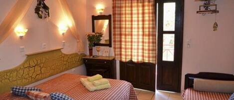 A bedroom with two beds, a television, and a door leading outside.