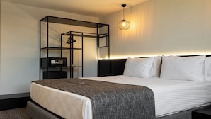 A modern hotel room with a large bed, a bedside table, a built-in shelf unit, and a pendant light. - INNO CONCEPT HOTEL (Antalya)