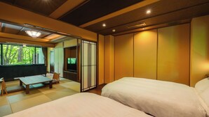 A room with two beds, a wooden table, and a sliding door leading to a balcony. - bettei tateshinakaorukaze (Chino)