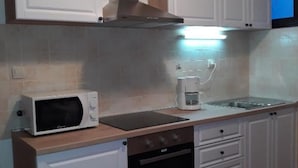 A kitchen with white cabinets, a microwave, a coffee maker, and a dishwasher.