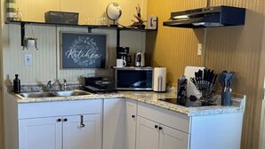 A compact kitchen with white cabinets, a granite countertop, a coffee maker, and a microwave. - Star Gazer  Hideaway (Bisbee)
