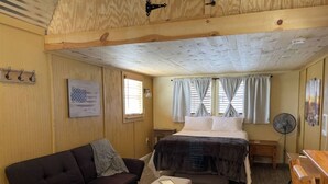 A cozy room with a bed, a sofa, a small table, and a fan. - Star Gazer  Hideaway (Bisbee)