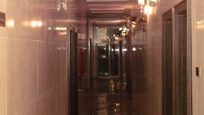 A corridor with reflective marble flooring, recessed lighting, and wall sconces. - Mo-House Hotel and Event Center (Abuja)