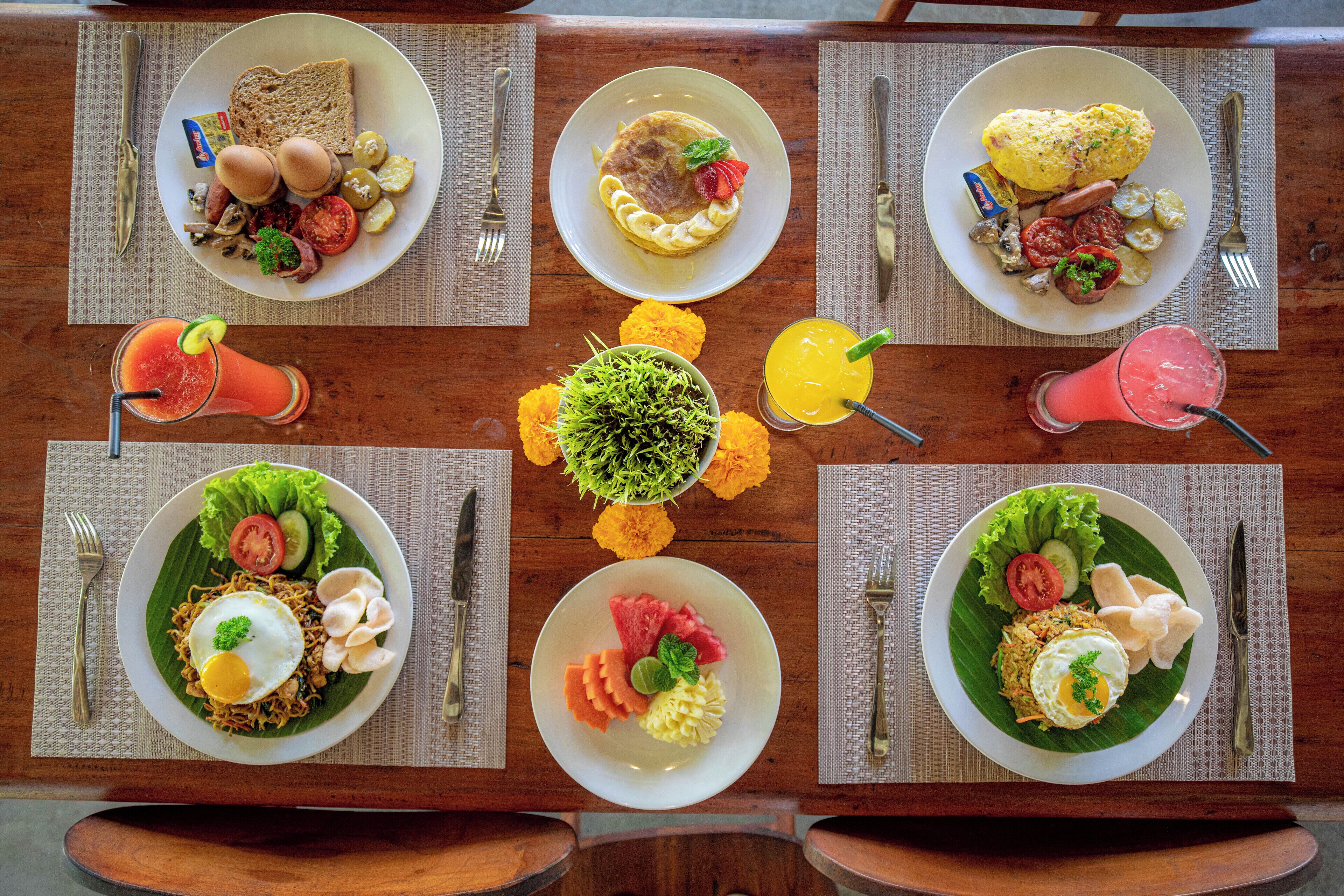 A table set with various breakfast dishes, drinks, and utensils.