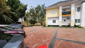 A parking lot with several cars and a red toolbox. - Cozy Residence (Abuja)