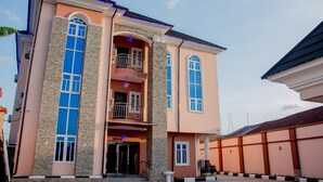 A two-story building with a central entrance, large windows, and a balcony. - Prismar International Hotel (Uyo)