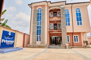 A two-story building with a stone facade, multiple balconies, and a welcoming entrance. - Prismar International Hotel (Uyo)