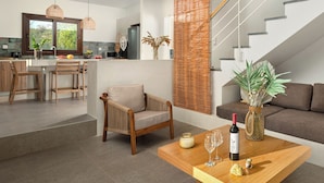 Un espacio habitable moderno con cocina, comedor y escalera.