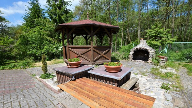 A wooden gazebo with a brick floor, surrounded by greenery and a stone oven. - Idyllic Villa with Private Pool in Trebusin Czech Republic (Dolní Týnec)