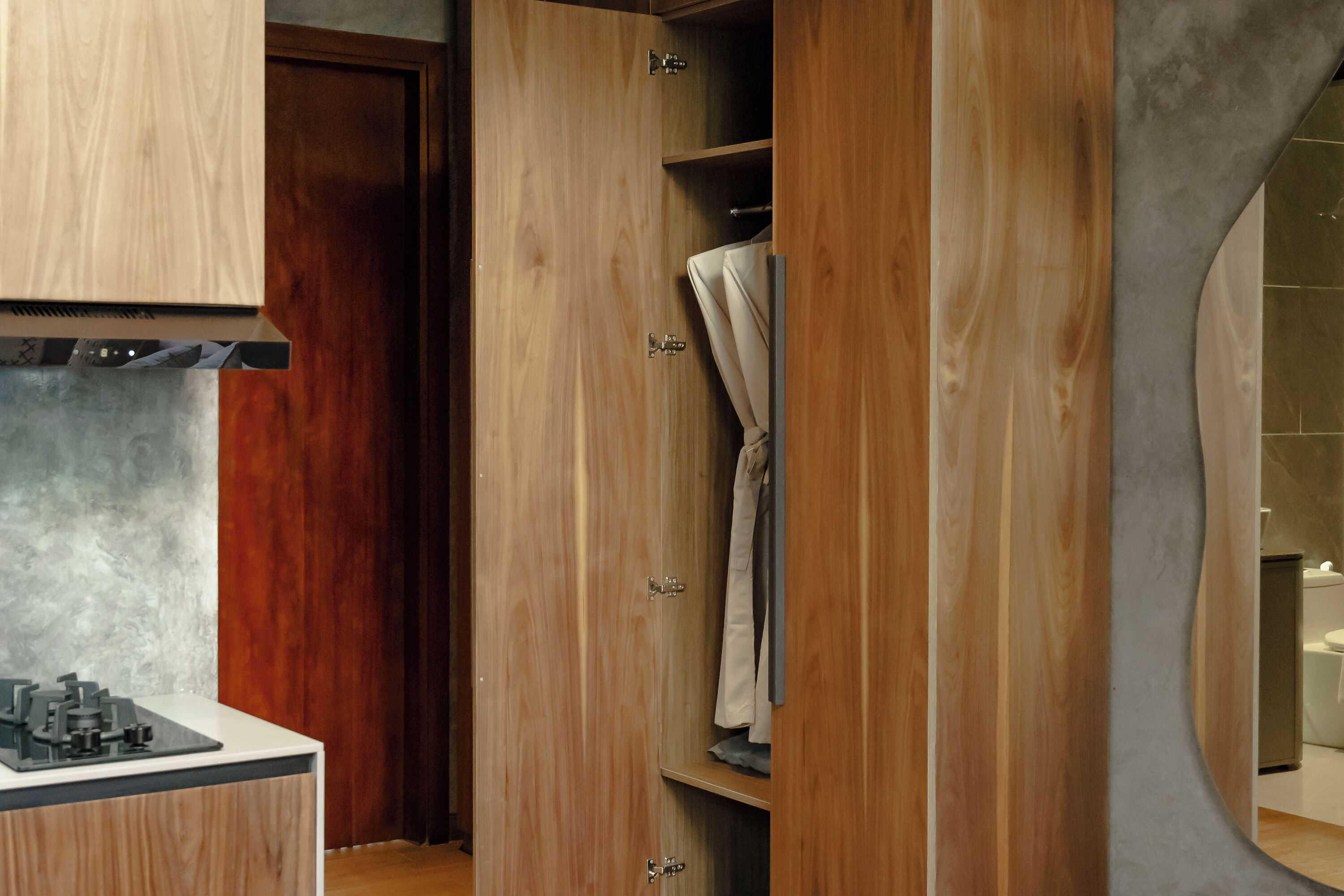 Une salle de bain moderne avec un meuble-lavabo en bois, un espace douche et un porte-serviettes apparent.
