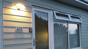 Ein Haus mit Hausnummer 435, einer Schiebetür aus Glas und einem Fenster mit weißem Rahmen.