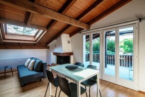 Relax in a spacious room with a dining table, fireplace, and balcony access.