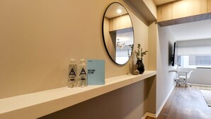 A reception area with a white reception desk, a mirror, and a welcome sign. - w * | Elegant 1BR in San Isidro (San Isidro)